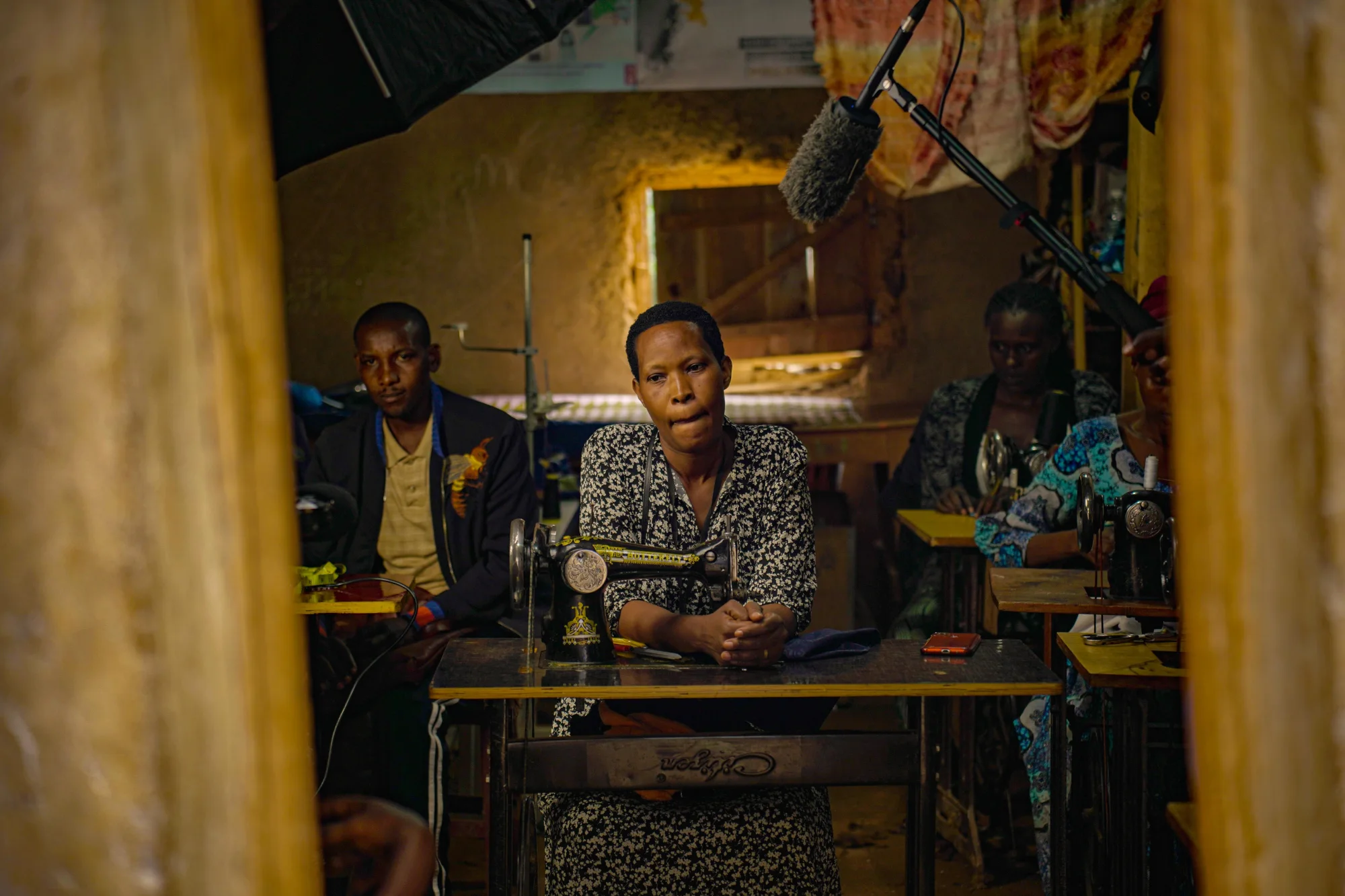 African tailoring team working with sewing machines and textiles in a production workshop